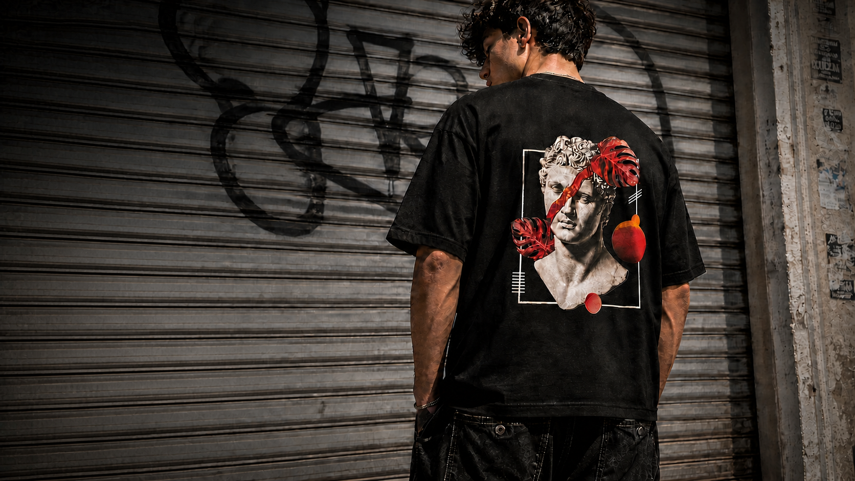 Model wearing a black graphic T-shirt from The Mafia Store.